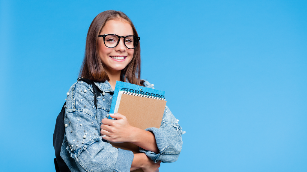 A student in a blue polo rests their chin on one hand while studying